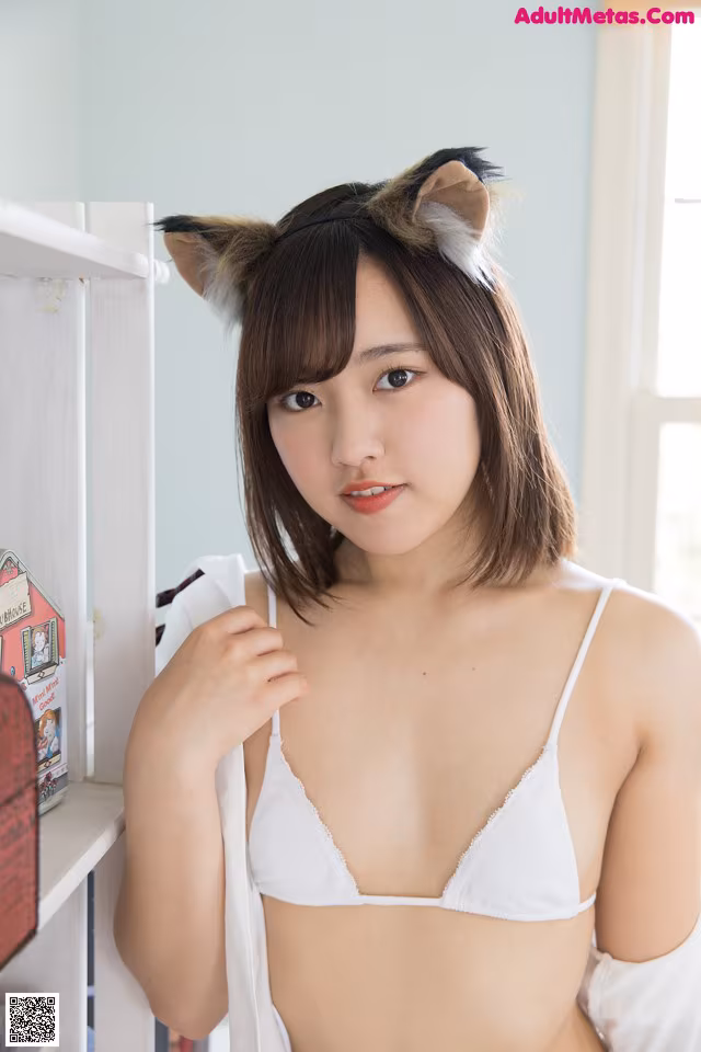 A woman wearing a white bra and a cat ears headband.