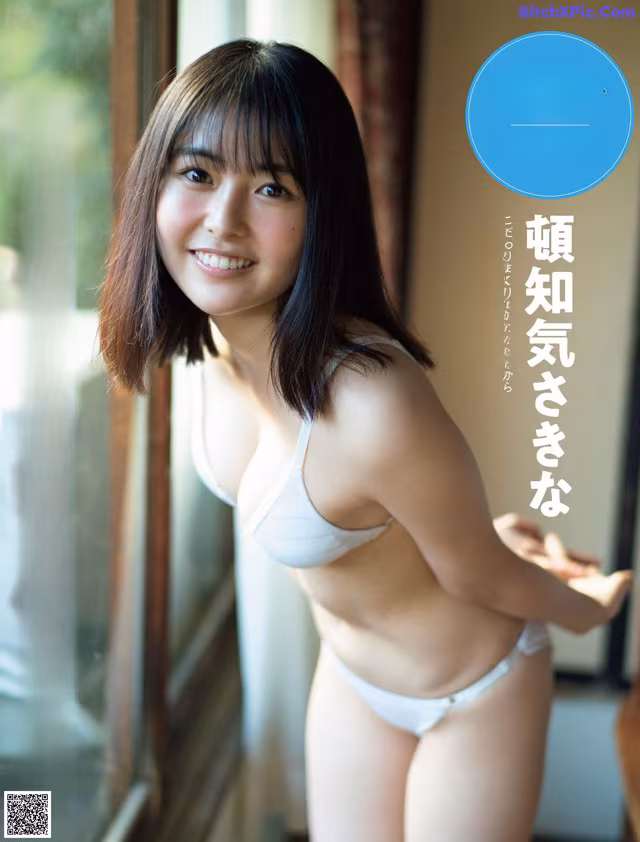 A woman in a white bra and panties standing by a window.