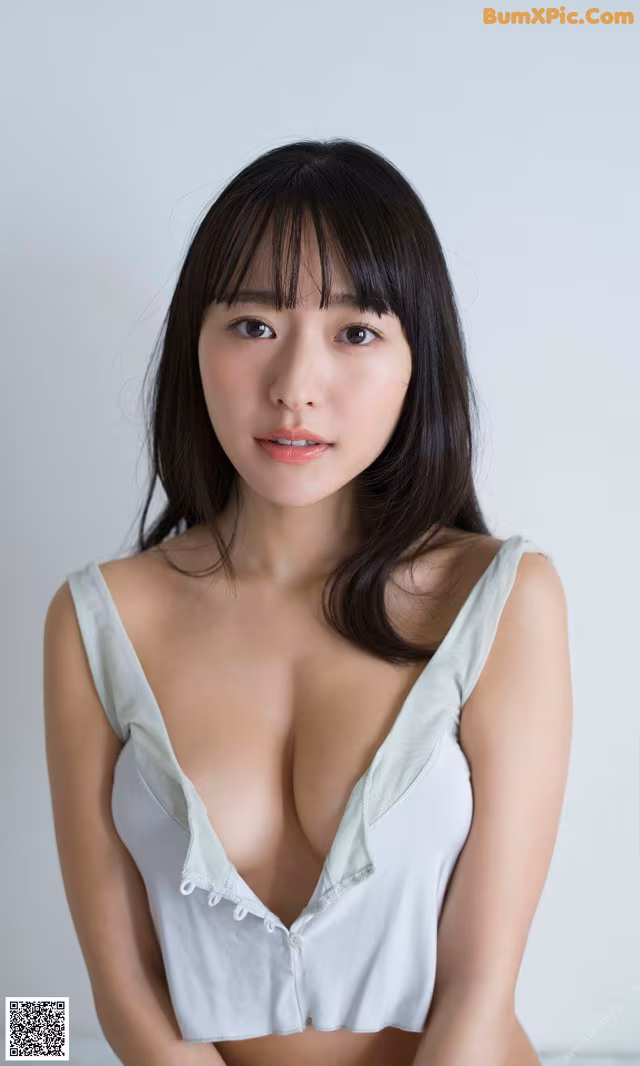 A woman in a white top is posing for a picture.
