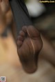 A close up of a person's foot with a pair of black stockings.