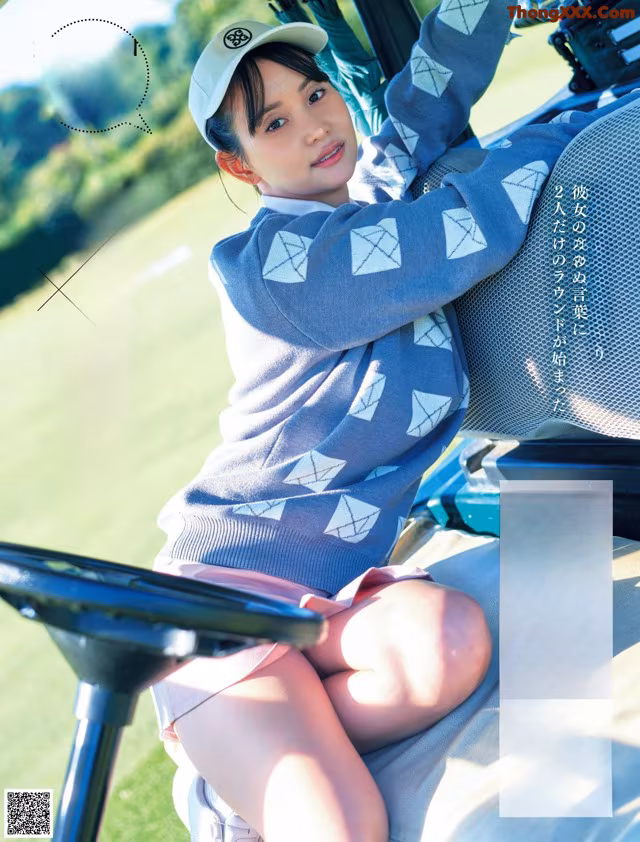 A woman sitting in a golf cart on a golf course.