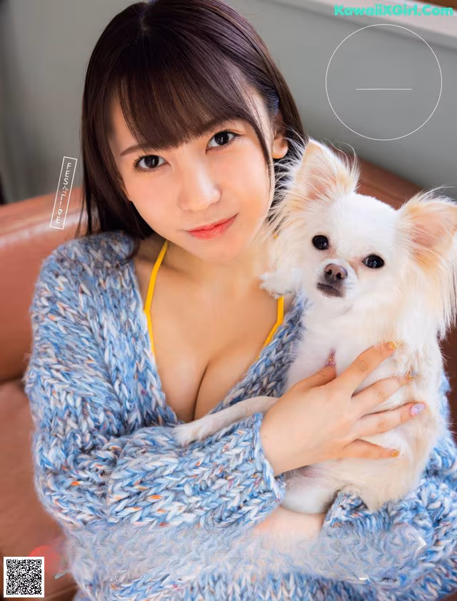 A woman holding a small white dog in her arms.