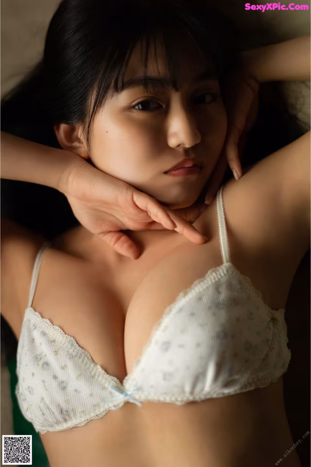 A woman in a white bra is posing for a picture.