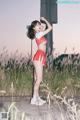 A woman in a red and white cheerleading uniform posing for a picture.